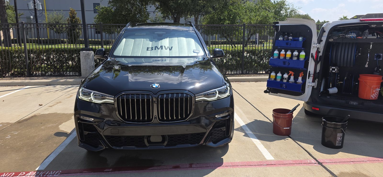 Black SUV exterior being detailed beside a mobile setup
